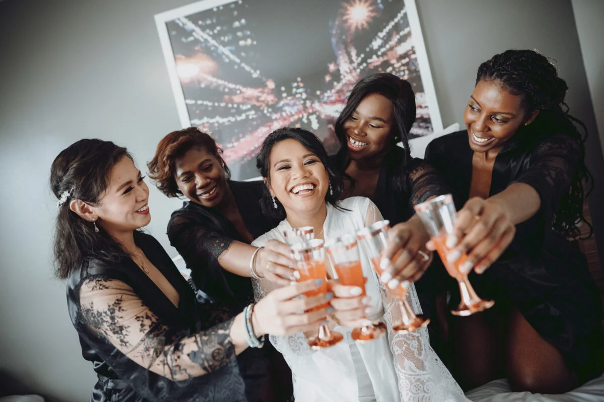 A group of bridesmaids toasting with champagne glasses.