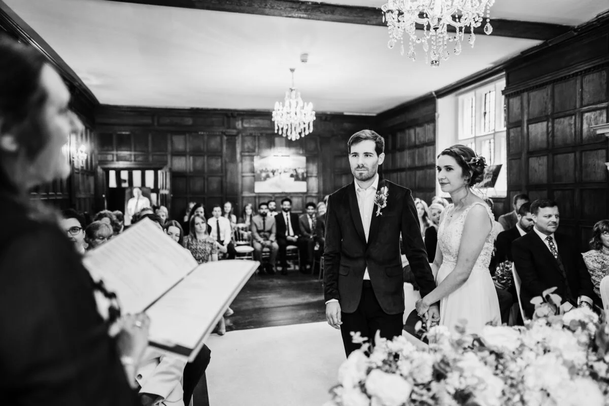 A black and white photo of a bride and groom walking down the aisle.
