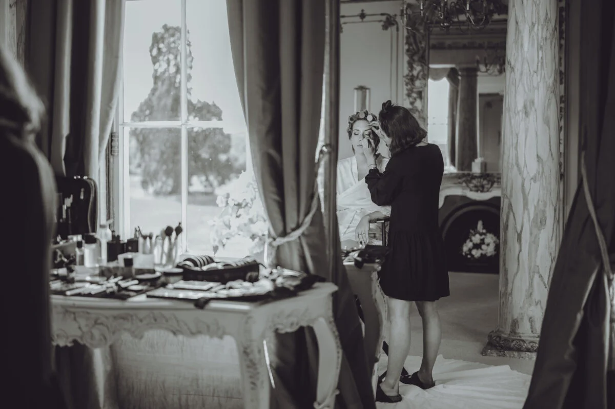 A woman is getting ready in front of a window.