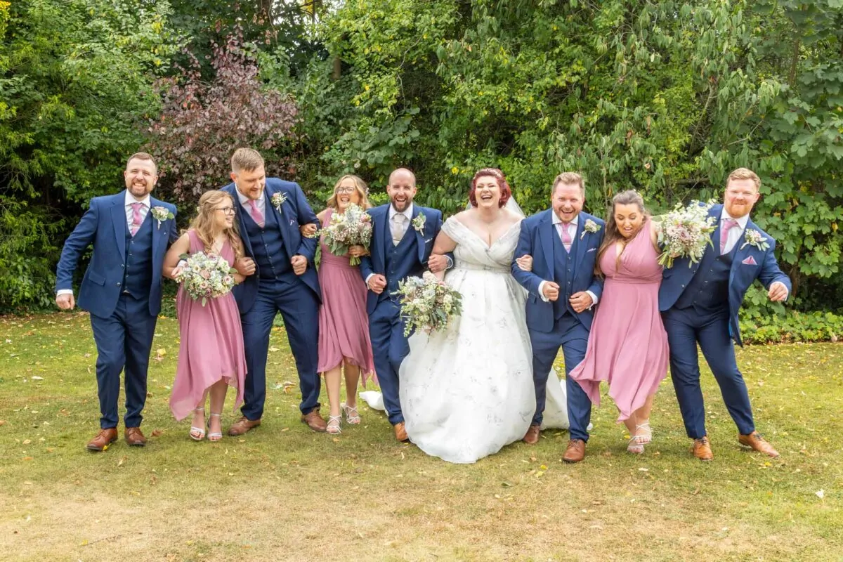 bride and groom having fun with bridal party