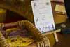 A rustic wedding sign on an easel next to a woven basket filled with items for guests inside the venue.