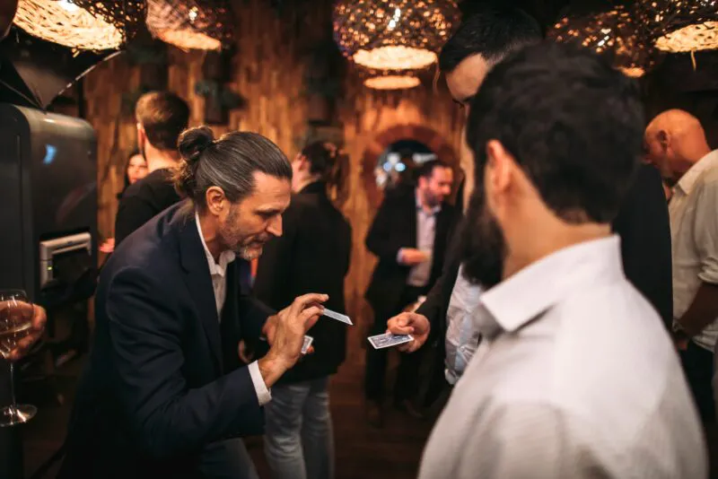 Corporate magician performing some strolling magic at event