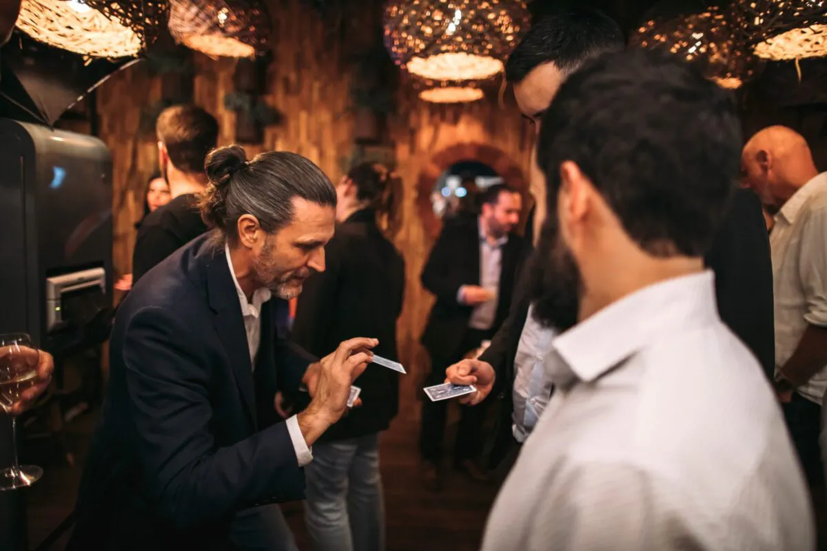 Corporate-magician-performing-some-strolling-magic-at-event-scaled
