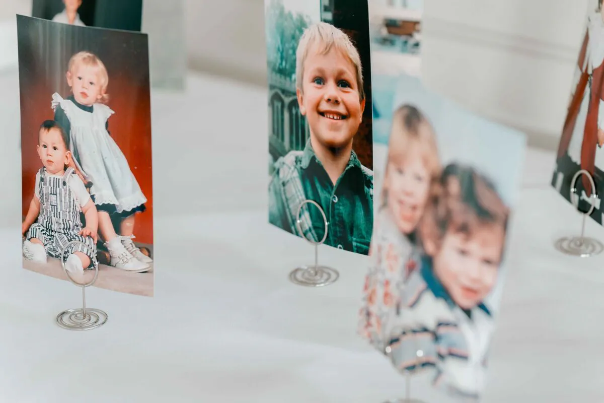 A nostalgic display of childhood photographs standing in wire card holders on a table.