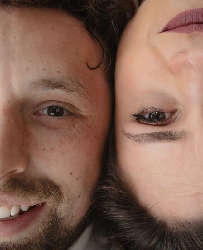 An extreme close up shot of a bride and groom lying head to head with soft natural light highlighting their faces and features.