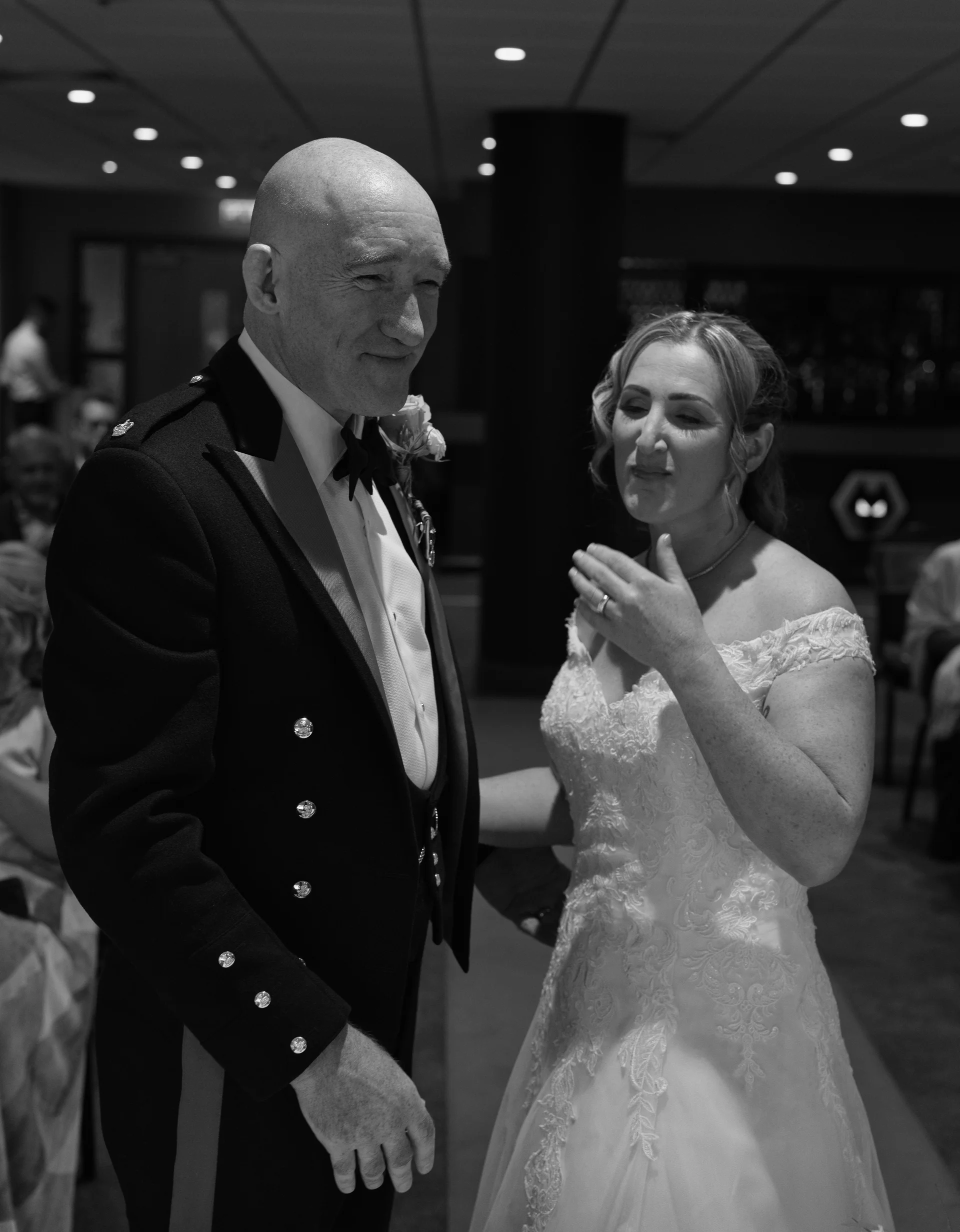 A mature bride and groom share an emotional moment together during their reception, captured in a striking black and white edit.