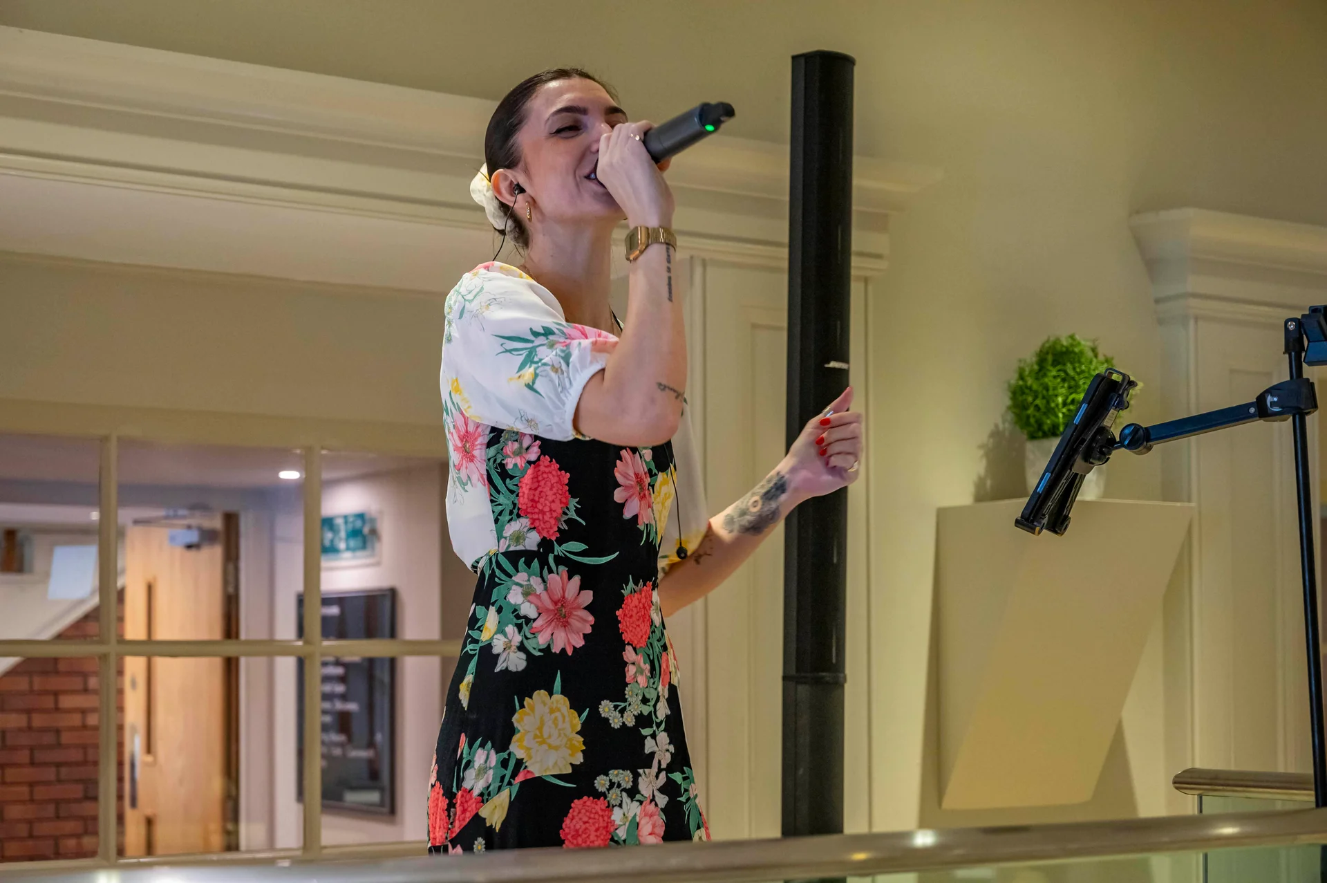 A female wedding singer enthusiastically performs into a microphone on stage during the evening reception.