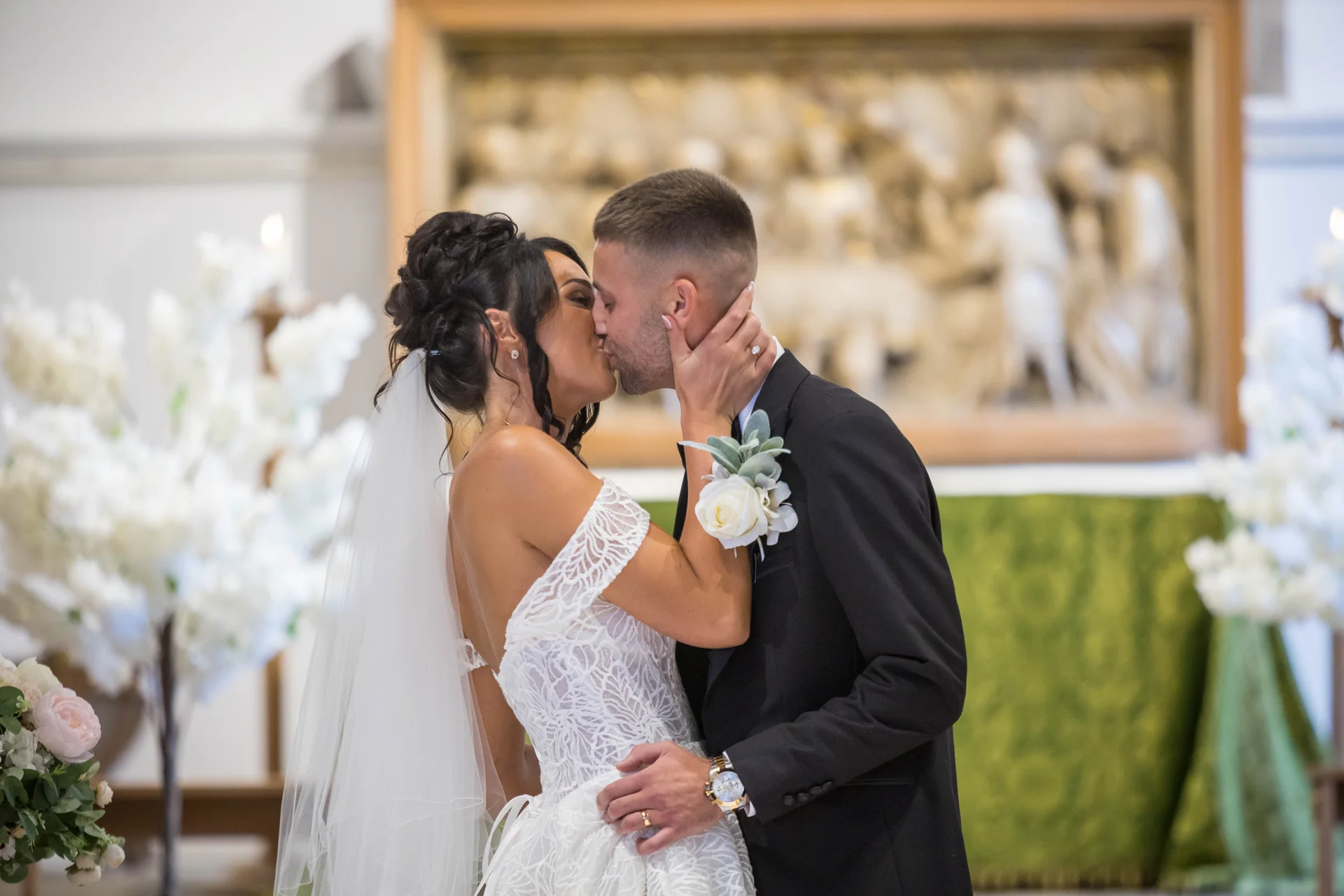 A newlywed couple shares their first kiss at the altar during a traditional church wedding ceremony.