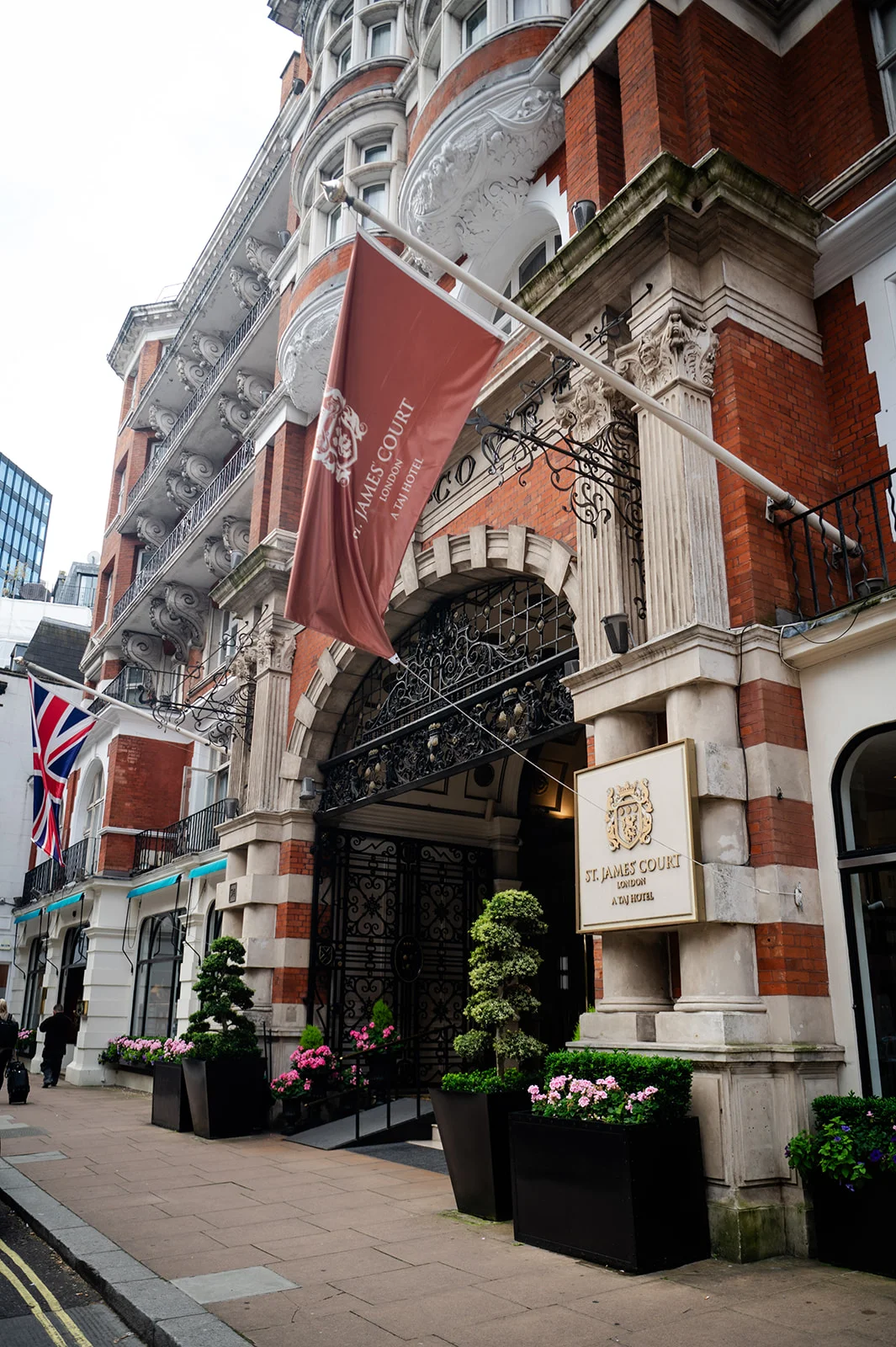 A detailed exterior view of the grand brick and stone facade of St James Court, a luxury London hotel hosting weddings.
