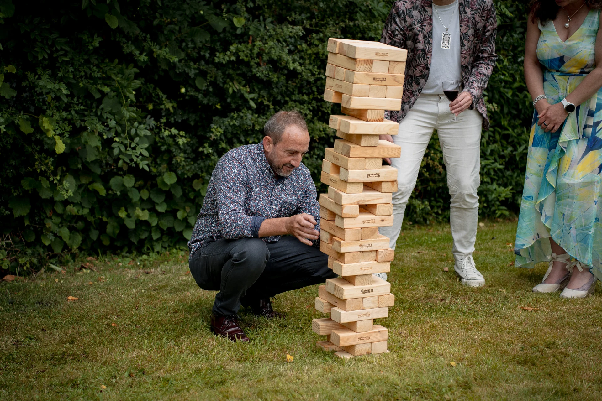 Wedding guests enjoy playing giant Jenga on the lawn during the outdoor drinks reception.