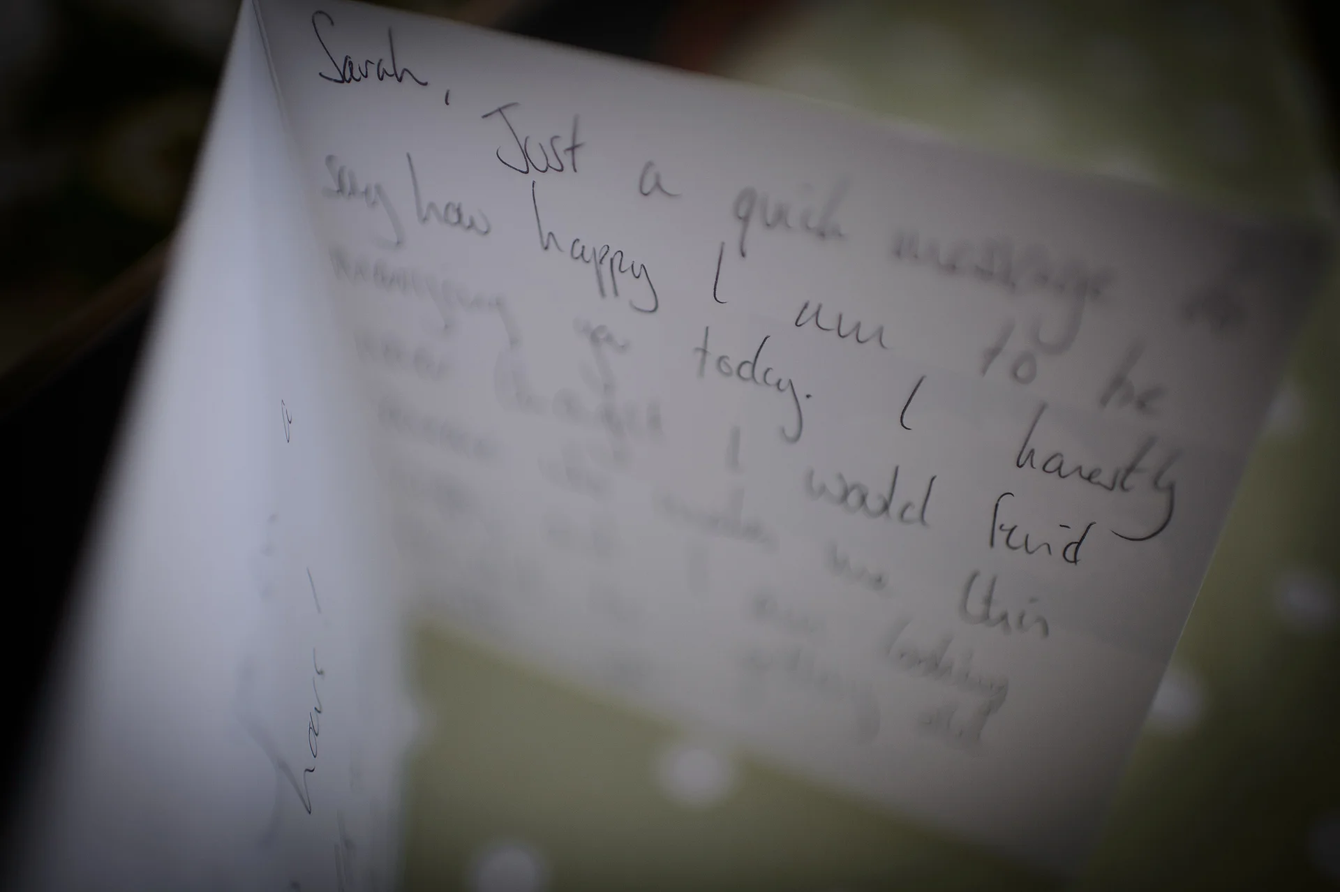 An intimate close-up shot capturing a handwritten wedding card addressed to the bride during morning preparations.